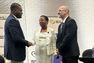 Director of the Emergency, Disaster Management and Special Services (EDMSS) Branch at the Ministry of Health and Wellness, Dr. Nicole Dawkins-Wright (centre) greets Director General of the Office of Disaster Preparedness and Emergency Management (ODPEM), Commander Alvin Gayle (left) ahead of the opening of the MOHW/PAHO Health After-Action Review – Hurricane Melissa, which is currently under way at the Moon Palace Hotel in Ocho Rios, Jamaica. At right is Pan American Health Organisation/World Health Organisation (WHO) Representative for Jamaica, Bermuda and the Cayman Islands, Ian Stein. 

