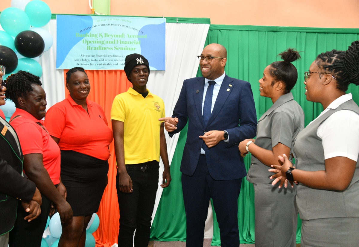 Minister of State in the Ministry of Industry, Investment and Commerce, Hon. Delano Seiveright (third right), is in conversation with students from Church Teachers’ College, during the recent staging of a financial readiness seminar at the institution in Mandeville, Manchester.
