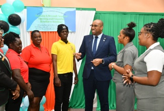 Minister of State in the Ministry of Industry, Investment and Commerce, Hon. Delano Seiveright (third right), is in conversation with students from Church Teachers’ College, during the recent staging of a financial readiness seminar at the institution in Mandeville, Manchester.
