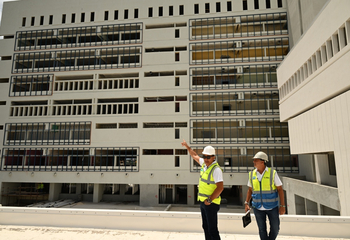Minister of Health and Wellness, Dr. the Hon. Christopher Tufton (left), points to the progress of work on the Cornwall Regional Hospital Redevelopment Project, during a tour in July 2025. He was accompanied by Project Manager, Vivian Gordon.

