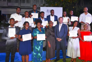British High Commissioner to Jamaica, Her Excellency Alicia Herbert (centre) and Deputy High Commissioner Jonathan Cook (third left), share a moment with the 2024/25 batch of Chevening Scholars, who are displaying their certificates of completion. Occasion was a reception to welcome home the scholars held on February 24 at the British High Commission in Kingston.