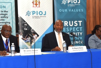 Director General of the Planning Institute of Jamaica (PIOJ), Dr. Wayne Henry (centre), addresses the agency’s quarterly hybrid media briefing on Tuesday (March 3). He is joined by Principal Director, James Stewart, and Deputy Director General, Claire Bernard.


