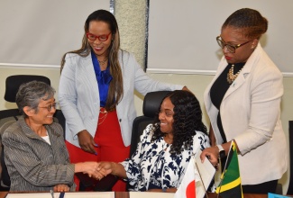 Permanent Secretary in the Ministry of Education, Skills, Youth and Information, Dr. Kasan Troupe (second left), and National Education Trust (NET) Executive Director, Latoya Harris-Ghartey (right), look on as Charge d