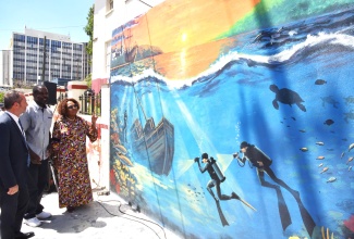 Minister of Culture, Gender, Entertainment and Sport, Hon. Olivia Grange; creator of the Underwater Cultural Heritage Mural on East Street in downtown Kingston, Keddan Savage (centre); and Regional Director and Representative of the United Nations Educational, Scientific and Cultural Organization (UNESCO) Cluster Office of the Caribbean, Eric Falt, examine the artwork during its official unveiling on Friday (March 13). The mural highlights Jamaica’s rich underwater cultural heritage, extending beyond shipwrecks, lost treasure, and the submerged sections of Port Royal following the 1692 earthquake, to also encompass places of memory linked to the nation’s history beneath the sea.

 