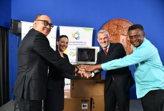 Minister of Health and Wellness, Dr. the Hon. Christopher Tufton (left), along with (from second left) Minister of Foreign Affairs and Foreign Trade, Senator the Hon. Kamina Johnson Smith; Ambassador of the Federal Republic of Germany to Jamaica, His Excellency Jan Hendrik van Thiel, and Executive Director of the Ministry of Health and Wellness’ National Healthcare Enhancement Foundation (NHEF), Courtney Cephas, celebrate the handover of 21 state-of-the-art patient monitors from Germany, valued at US$ 25,000, for the public health system, during a ceremony, held today (March 16), at the Office of the Prime Minister in St. Andrew.

