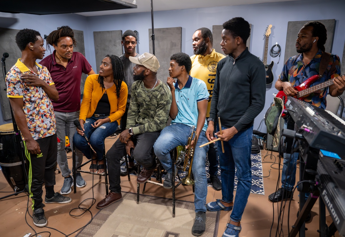 Reggae Music Director, Tourism Entertainment Academy, Othneil “Taddy P” Campbell (second left), in conversation with members of the Reggae Band during one of their rehearsal sessions.


