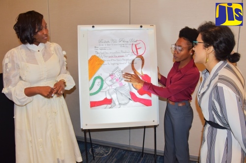 Children's Advocate, Diahann Gordon Harrison (left) and United Nations Children's Fund (UNICEF) Child Protection Specialist, Marjana Badas (right) listen as Edna Manley College of the Visual and Performing Arts student, Samelia Sybblis, explains details of artwork depicting the impact of corporal punishment.  Occasion was the Office of the Children's Advocate (OCA) Dinner & Conversations event held recently at AC Hotel by Marriott in Kingston. 