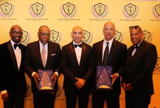 Jamaica’s Ambassador to the United States, His Excellency Major General (Ret’d) Antony Anderson (centre), joins 2026 David  “Wagga”Hunt Foundation honorees George Willie (second left), an accounting pioneer, and Wayne Hewett (second right), a corporate leader, after they received their awards during the Foundation’s 12th annual red‑carpet gala at the National Education Association Atrium in downtown Washington, DC. Looking on (from left) are Organising Committee member Michael McPherson and Foundation Chairman, Christopher Hunt.

