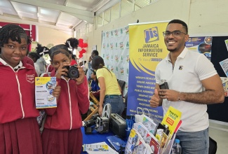 Special Projects Manager at the Jamaica Information Service (JIS), Paul Allen (right), engages with Ferncourt High School students Mia-Lee Lowe (left) and Cindia McFarlane, who visited the agency's booth, during a recent college fair held at the school's campus in Claremont, St. Ann.