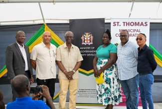 Minister of Local Government and Community Development, Hon. Desmond McKenzie (third left) along with (from left) Chief Executive Officer of the St. Thomas Municipal Corporation, Kevin McIndoe; Member of Parliament for St. Thomas Western, James Robertson; Vendor, Rose Carlyle Robinson; Yallahs Division Councillor, John Lee, and Mayor of Morant Bay, Councillor Louis Chin, pause for a photo opportunity during the opening of the Yallahs market on March 27.
