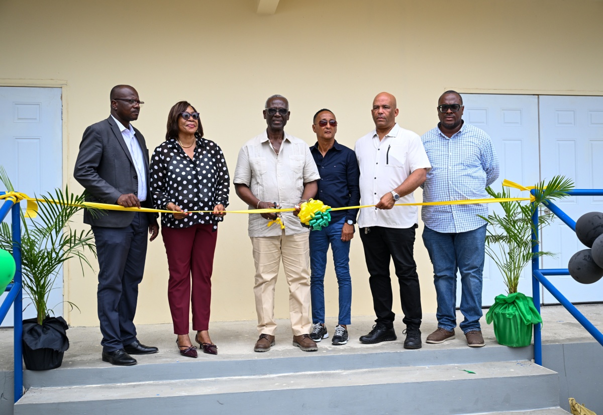 Minister of Local Government and Community Development, Hon. Desmond McKenzie (third left), and Mayor of Morant Bay, Councillor Louis Chin (third right), lead the ribbon-cutting to signify the opening of the St. Thomas Night Shelter on March 27. Joining them are (from left), Chief Executive Officer of the St Thomas Municipal Corporation, Kevin McIndoe; Member of Parliament for St. Thomas Eastern, Yvonne Shaw; Member of Parliament for St. Thomas Western, James Robertson,and Chairman of the Poor Relief Committee and Councillor for the Yallahs Division, John Lee.