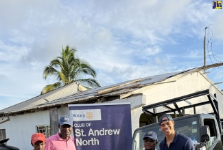 Jamaica Constabulary Force (JCF) sub-officer in charge of traffic for St. Elizabeth, Sergeant Albert Simpson (second left), stands beside his father Allan Simpson (left), of Melsham in St. Elizabeth, who lost his roof during Hurricane Melissa last October.  They are joined by President of the Rotary Club of St. Andrew North, Pierpont Wilson (second right) and Founder of United States (US)-based health and fitness company KR Method, Korey Rowe. Occasion was the donation of building material for the rebuilding of the Simpson family home by the Rotary Club and KR Method.