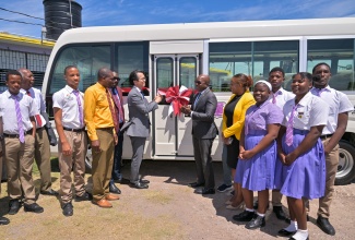 Minister of Labour and Social Security and Member of Parliament for Clarendon South Eastern, Hon. Pearnel Charles Jr. (sixth right), and Ambassador-designate of Japan to Jamaica, His Excellency Kohei Maruyama (sixth left), cut the ribbon to officially hand over a new school bus to Bustamante High School on Thursday (March 5) at the institution’s grounds in Lionel Town, Clarendon. Joining the moment are Principal, Bustamante High School, Wayne Evans (fourth from left); Regional Director, Region 7, Ministry of Education and Youth, Barrington Richardson (fifth from left); Executive Director of the National Education Trust (NET), Latoya Harris Ghartey (fifth from right); other stakeholders and students. The vehicle was donated through the Government of Japan’s Grant Assistance for Grassroots Human Security Projects to improve transportation, safety and access to school activities for students and staff.

