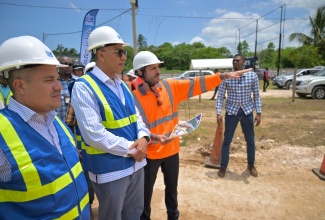 Prime Minister, Dr. the Most Hon. Andrew Holness (centre), and Minister of Water, Environment and Climate Change, Hon. Matthew Samuda (left), are briefed on works being carried out at the Rio Cobre Water Treatment Plant project site in Content, St. Catherine, by Director of Water at VINCI Construction Grands Projets, Geoffrey Desportes, during a tour of the site in May 2025.