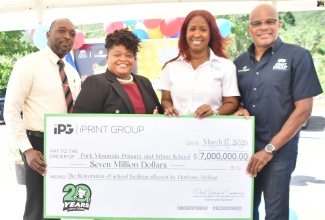 Principal of the Park Mountain Primary and Infant School in Santa Cruz , St. Elizabeth, Carlene Williams-Heath (second left), receives a cheque for $7 million from Chairman of the iPrint Group of Companies, Stephen Steele (right), at the school on Tuesday (March 17). Also taking part are (from left) Education Officer at the Ministry of Education, Skills, Youth and Information – Region 5, Gregory King, and Donor Project Coordinator at the National Education Trust (NET), Danielle Drummond. 

