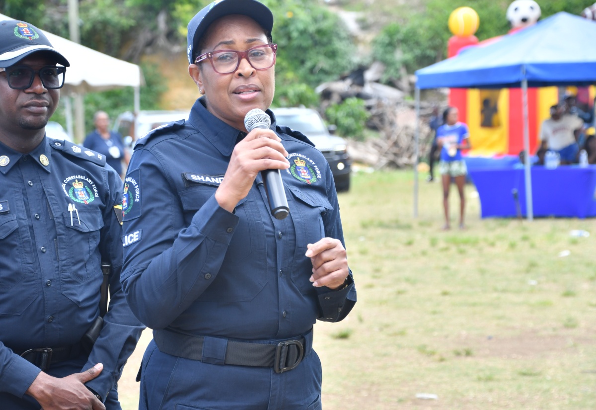 Assistant Commissioner of Police (ACP) in charge of the Community Safety and Security Branch, Charmaine Shand (right), addresses the Jamaica Constabulary Force (JCF) Domestic Violence Intervention Unit Cross Country Tour stop at the Cornwall Gardens playfield in Mt. Salem, St. James, recently.  Listening is Commanding Officer for St. James, Senior Superintendent of Police, Eron Samuels.  

