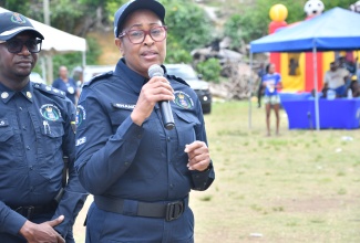 Assistant Commissioner of Police (ACP) in charge of the Community Safety and Security Branch, Charmaine Shand (right), addresses the Jamaica Constabulary Force (JCF) Domestic Violence Intervention Unit Cross Country Tour stop at the Cornwall Gardens playfield in Mt. Salem, St. James, recently.  Listening is Commanding Officer for St. James, Senior Superintendent of Police, Eron Samuels.  

