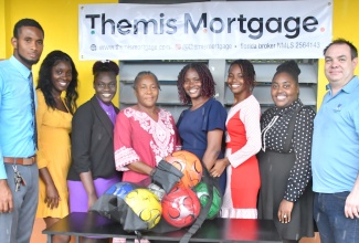 Acting Principal at Brampton Primary School in Trelawny, Monica McBean (fourth left) is joined by the teaching staff in accepting a donation of furniture and soccer balls from President of Themis Mortgage in the United States, Chris Perry (right). The items were handed over at the institution on Thursday (March 19).