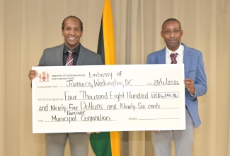 State Minister in the Ministry of Foreign Affairs and Foreign Trade, Hon. Alando Terrelonge (left), and Chief Financial Officer of the Hanover Municipal Corporation, Romeo Daley, display a cheque donated by the Jamaican Diaspora to benefit the Hanover Infirmary. The presentation took place on Tuesday (April 21) at the Ministry in downtown Kingston.