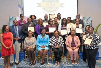 Minister of Culture, Gender, Entertainment and Sport, Hon. Olivia Grange (second right, seated), and Principal Director at the Bureau of Gender Affairs (BGA), Sharon Coburn Robinson (seated second left), join gender focal points from various Ministries, Departments and Agencies (MDAs) who received certification after completing training and securing approval for their gender action plans, along with other stakeholders, at the Gender Mainstreaming Certification and Recertification Ceremony held on April 23 at the AC Hotel by Marriott Kingston.