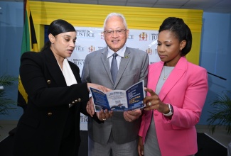 Minister of Justice and Constitutional Affairs, Hon. Delroy Chuck (centre); Administrator-General, Stacie-Ann Carty (right); and Senior Policy Analyst in the Ministry, Sandy-Lue Cole Jarrett, read a brochure on alternative dispute resolution (ADR). The interaction was captured during the launch of the ADR Policy Development and Estate Planning Public Education Campaign at the Ministry’s office in Kingston on Wednesday (April 29).
