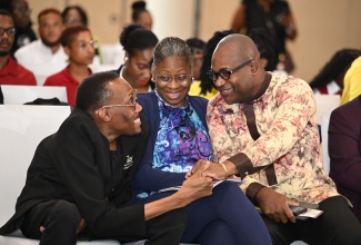 Founder and Executive Director of the Jamaican Association for Debating and Empowerment (JADE), Germaine Barrett (left), exchanges greetings with Principal and Pro-Vice-Chancellor of The University of the West Indies, Mona, Densil Williams, during the launch of the TIU Public Sector Debate Competition on Tuesday (April 14) at the AC Marriott Hotel in Kingston. Sharing the moment is Executive Director of the Transformation Implementation Unit (TIU), Maria Thompson Walters (centre).

