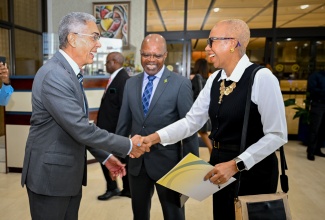 Minister of Finance and the Public Service, Hon. Fayval Williams (right), is greeted by Governor, Bank of Jamaica (BOJ), Richard Byles (left), on arrival at the Bank