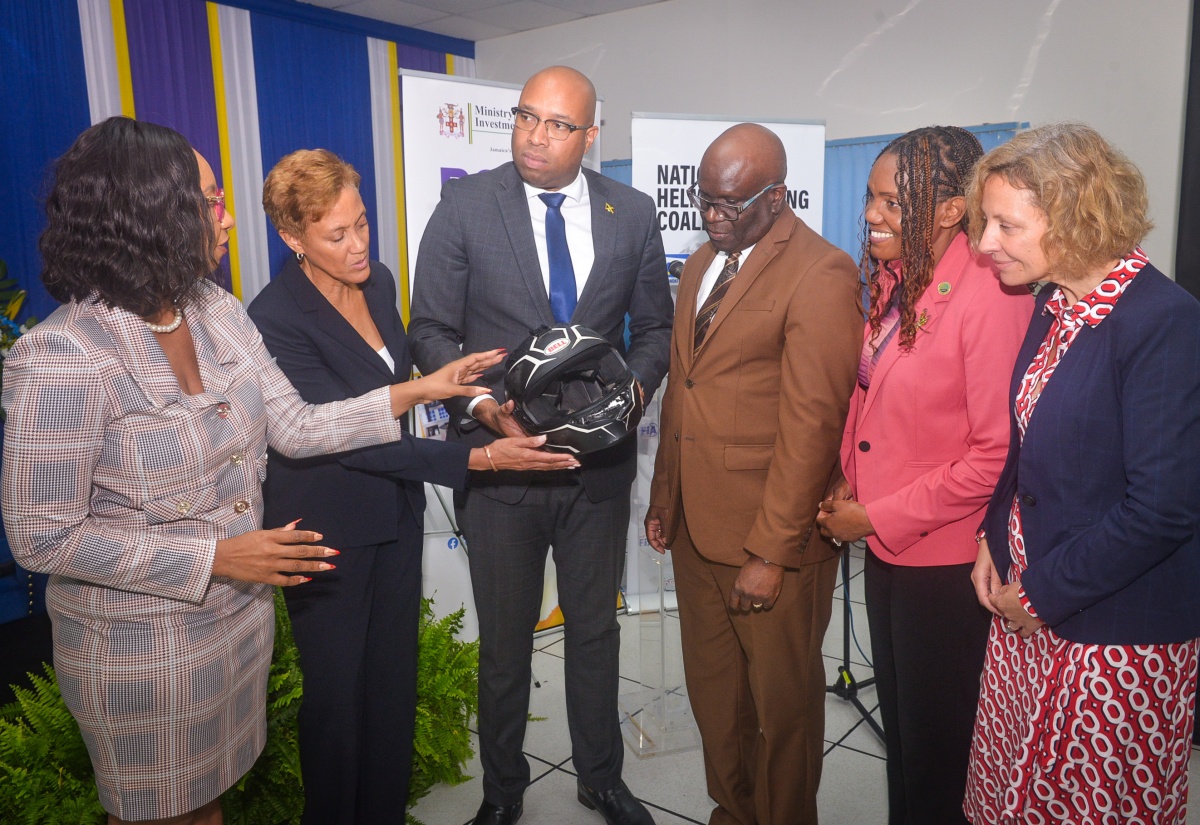 State Minister in the Ministry of Industry, Investment and Commerce, Hon. Delano Seiveright (left); Executive Director of the Bureau of Standards Jamaica (BSJ), Dr. Velton Gooden, and 

Chief Executive Officer of the CARICOM Regional Organization for Standards and Quality, Dr. Sharonmae Smith Walker, examine a helmet at the launch of the BSJ Motorcycle Helmet standard - JS 374:2025 Jamaica Standard Specification – Protective Helmets for Road Users - on March 31 at the Jamaica Business Development Corporation (JBDC) Incubator and Resource Centre in Kingston.
