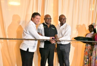 Tourism Minister, Hon. Edmund Bartlett (centre), cuts the ribbon to officially reopen the Bahia Principe Runaway Bay in St. Ann on Wednesday (April 1). Joining Mr. Bartlett are (from left) Managing Director of Bahia Principe, Jonay Guerra, and Tourism Director, Donovan White.