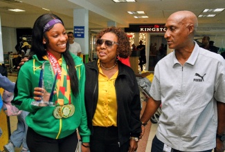 Minister of Culture, Gender, Entertainment and Sport, Hon. Olivia Grange (centre), and President, Jamaica Amateur Athletics Association (JAAA), Garth Gayle (right), engage with winner of the Austin Sealy Award at the 2026 CARIFTA Games, Shanoya Douglas. The Minister was at the Norman Manley International Airport on Tuesday (April 7) to welcome home the junior track and field athletes, which again topped the CARIFTA medal table with 71 medals.
