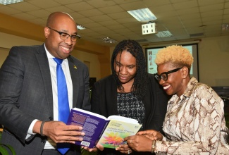 State Minister for Industry, Investment and Commerce, Hon. Delano Seiveright, joins Deputy Director/Legal Counsel, Jamaica Intellectual Property Office, Shantel English Richards (centre), and Vice President of Exports, Jamaica Promotions Corporation (JAMPRO), Sophia Linton, in perusing the new 