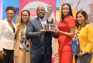 State Minister in the Ministry of Education, Skills, Youth and Information, Hon. Rhoda Moy Crawford (fourth left), presents the LASCO/Ministry of Education, Skills, Youth and Information/Jamaica Teaching Council Principal of the Year trophy to Principal of St. Mary Technical High School, Orville Richards (centre), during the awards ceremony, held at The Jamaica Pegasus hotel in New Kingston on March 25. Sharing in the presentation (from left) are Chief Executive Officer of the Lasco Chin Foundation, Professor Rosalea Hamilton; Permanent Secretary in the Ministry, Dr. Kasan Troupe; and Deputy General Manager of Lasco Manufacturing, Lisa Watts.
