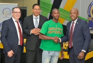 Minister of Labour and Social Security, Hon. Pearnel Charles Jr. (right), greets the youngest farm worker for the April 2026 season, Reneil Chambers, who will be participating in the Seasonal Agricultural Workers Programme (SAWP) for the first time. The occasion was the launch of the Government of Jamaica’s SAWP (GOJ/SAWP) Scholarship, held on Tuesday (March 31) at the Ministry’s Overseas Employment Centre, East Street, downtown Kingston. Sixty scholarships will be awarded at the start of the 2026 academic year, in recognition of the SAWP’s 60th anniversary. Sharing the moment (from left) are Canada’s High Commissioner to Jamaica, His Excellency Mark Berman, and State Minister in the Ministry of Labour and Social Security, Hon. Donovan Williams. 
