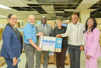 State Minister in the Ministry of Health and Wellness, Hon. Krystal Lee (third right), receives Inter-Agency Reproductive Health (IARH) Kits and Dignity Kits during the handover ceremony on Wednesday (April 1) at the United Nations Population Fund (UNFPA) Warehouse in downtown Kingston. Sharing the moment are (from left) International Pan American Health Organisation (PAHO) Consultant, Health Emergencies (Caribbean), Dr. Marion Bullock DuCasse; PAHO/World Health Organisation (WHO) Representative for Jamaica, Bermuda and the Cayman Islands, Ian Stein; United Nations (UN) Resident Coordinator for Jamaica, Bermuda, Cayman Islands and Turks and Caicos, Dennis Zulu; Director and Representative of UNFPA, Harold Robinson; and National Maternal and Neonatal Health Coordinator and Public Health Specialist, Ministry of Health, Dr. Carol Lord.