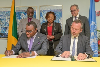 Permanent Secretary in the Ministry of Culture, Gender, Entertainment and Sport, Deanroy Bernard (seated left) and Regional Director and Representative of the United Nations Educational, Scientific and Cultural Organisation (UNESCO) Regional Office for the Caribbean, Eric Falt (seated right) sign the Declaration of Intent for the Establishment of a Culture and Creative Industries Fund on Thursday (April 2), at the Ministry