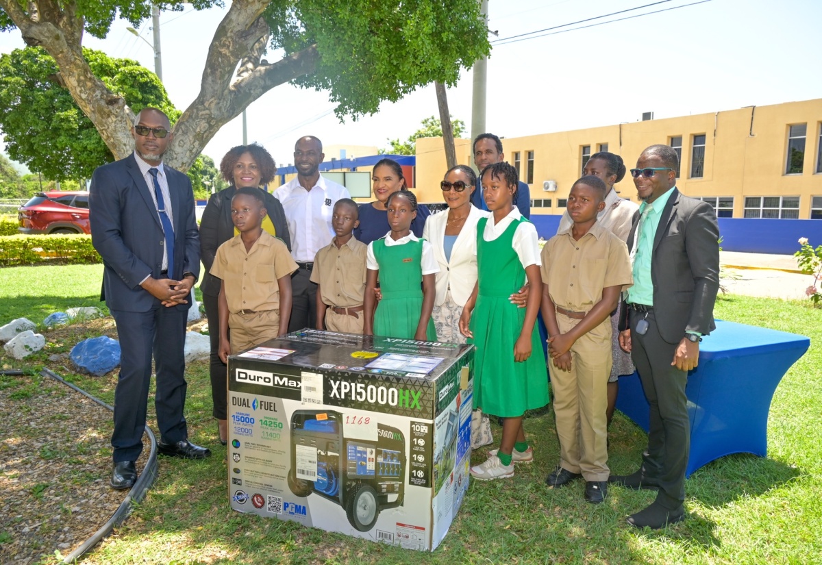 Minister of State in the Ministry of Tourism, Hon. Tova Hamilton (third right, front row), poses with students from Mulgrave Primary School in St. Elizabeth, which is among the beneficiaries of 20 dual‑fuel 15,000‑watt portable generators donated for distribution to educational institutions most affected by Hurricane Melissa. The generators were handed over during a ceremony held on Tuesday (April 7) at the National Education Trust (NET) Building, Caenwood Centre, Kingston. The donation was made possible through a collaboration involving Jamaica Vacations Limited (JamVac) and the Mediterranean Shipping Company (MSC) Foundation, based in Geneva, Switzerland, with support from its local affiliate, MSC Jamaica Limited. Other participating stakeholders include (from left, back row) Senior Education Officer, Region Four, Ministry of Education, Skills, Youth and Information, Everette Riley; NET Executive Director, Latoya Harris-Ghartey; MSC Jamaica Limited Managing Director, Roger Hinds; JamVac Executive Director, Joy Roberts; Tourism Enhancement Fund (TEF) Executive Director, Dr. Carey Wallace; Assistant Chief Education Officer in the Education Ministry