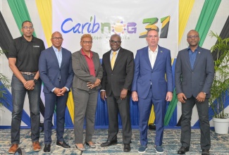 Minister of Energy, Transport and Telecommunications, Hon. Daryl Vaz (second right), shares lens with (from left) Chief Executive Officer (CEO) of Arkitechs Inc., Stephen Lee; Chairman of Caribbean Datacentre Association, Giovanni King; Director of Research and Stakeholder Engagement at Caribbean Network Operators Group (CaribNOG), Dr. Claire Craig; Director General of the Office of Utilities Regulation (OUR), Ansord Hewitt; and CaribNOG Co-founder, Bevil Wooding, during the 31st  staging of the CaribNOG Forum, held on Tuesday (April 14) at The Jamaica Pegasus hotel in New Kingston. 
