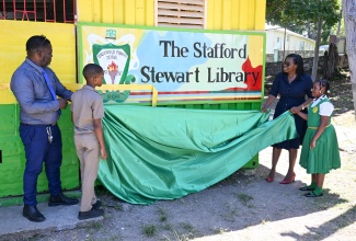 Principal of Duckenfield Primary and Infant School in St. Thomas, Stafford Thomas, and Education Officer for Region Two in the Ministry of Education, Skills, Youth and Information, Marcia Dallas-McKenzie, unveil the sign to the institution