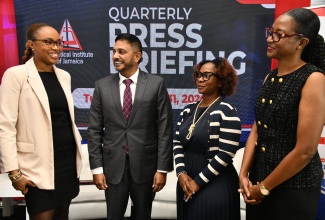 Statistical Institute of Jamaica (STATIN) Director General, Leesha Delatie-Budair (left), converses with fellow STATIN executives, during Tuesday’s (March 31) quarterly press briefing held at Terra Nova All-Suite Hotel in Kingston. Sharing the conversation (from second left) are Director of the Economic Accounting Division, Chandar Henry; Acting Director of Administrative Statistics, Siomara McDonald; and Acting Deputy Director General and Director, Surveys Division, Dr. Natalee Simpson.