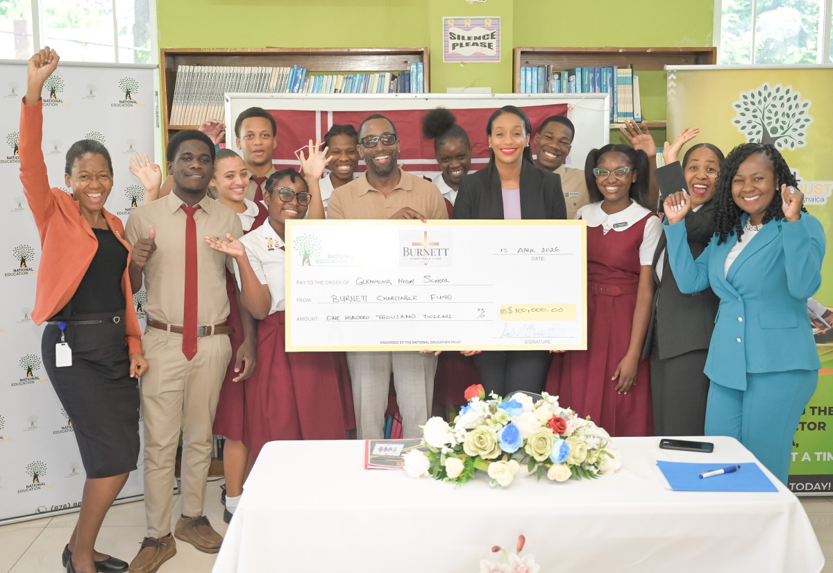 Minister of State in the Ministry of Education, Skills, Youth and Information, Hon. Rhoda Moy Crawford (front, fifth left); Head of the Burnett Family Foundation, Dale Burnett (front, fourth left); Director for Donor and Partnership Management at the National Education Trust (NET), Keisha Johnson (right), along with students, teachers and other officials, celebrate the handover of a cheque valued US$100,000 from the Burnett Family Foundation to the Clarendon-based Glenmuir High School, on April 13.

