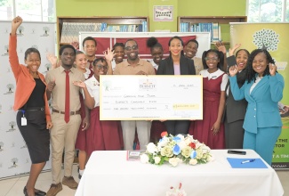 Minister of State in the Ministry of Education, Skills, Youth and Information, Hon. Rhoda Moy Crawford (front, fifth left); Head of the Burnett Family Foundation, Dale Burnett (front, fourth left); Director for Donor and Partnership Management at the National Education Trust (NET), Keisha Johnson (right), along with students, teachers and other officials, celebrate the handover of a cheque valued US$100,000 from the Burnett Family Foundation to the Clarendon-based Glenmuir High School, on April 13.
