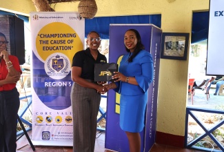 Head of the Jamaica Public Service Company (JPS) Foundation, Sophia Lewis, makes a presentation to Region Four Education Officer, Ministry of Education, Skills, Youth and Information, Dr. Patricia Mumby Lalor, at the official launch of the JPS extra lesson programme for St. Elizabeth and Westmoreland students at Jack Sprat Treasure Beach in St. Elizabeth on April 7.