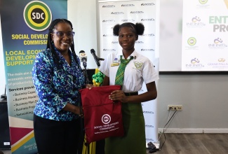 Director of Local Economic Development at the Social Development Commission (SDC), Avril Ranger (left), makes a presentation to student of the Knockalva Technical High School, Sanisha Roach  (right), at the Social Development Commission (SDC) Hanover Youth Entrepreneurship Programme (YEP) launch, held at the Grand Palladium Jamaica Resort and Spa in Lucea on Wednesday, April 15.