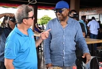 Tourism Minister, Hon. Edmund Bartlett (right), engages with Jack Sprat Restaurant owner and hotelier, Jason Henzell, during a visit to the Lovers’ Leap attraction in St. Elizabeth on Friday (April 24), as part of the second day of the South Coast Confidence Tour.