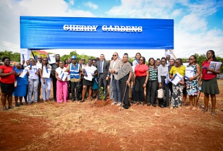 Prime Minister, Dr. the Most Hon. Andrew Holness (centre), and Minister of Health and Wellness and Member of Parliament for St. Catherine West Central, Dr. the Hon. Christopher Tufton (eighth right, front row), share a moment with beneficiaries of 34 serviced lots at the Cherry Gardens Housing Development in Kitson Town, St. Catherine, at the handover ceremony on Wednesday (April 15). The lots were developed by the National Housing Trust (NHT).
