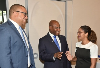 Minister of Industry, Investment and Commerce, Senator the Hon. Aubyn Hill (centre) in discussion with Interim Chief Executive Officer, National Commercial Bank Jamaica Limited (NCB), Sheree Martin (right) and Executive Vice President, Retail Banking Division, National Commercial Bank Jamaica Limited, Perrin Gayle during the NCB SME Growth Fund II luncheon at the AC Marriot Hotel in New Kingston on April 16.