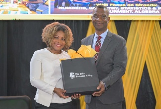 President of The Mico University College, Dr. Asburn Pinnock (right), presents a gift to Minister of Education, Skills, Youth and Information, Senator Dr. the Hon. Dana Morris Dixon, at the University’s recent Mathematics Expo 2026, held at the institution.
