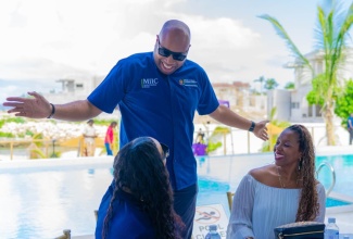 State Minister in the Ministry of Industry, Investment and Commerce, Hon. Delano Seiveright, shares a light moment with attendees during the Paradisiac Sip & See Wealth Summit in Richmond, St. Ann, on  March 29.

