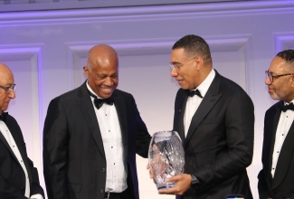 Prime Minister, Dr. the Most Hon. Andrew Holness (second right), accepts the American Foundation for the University of the West Indies (AFUWI) Legacy Award, presented to him by UWI Vice Chancellor, Sir Hilary Beckles (second left), during the AFUWI