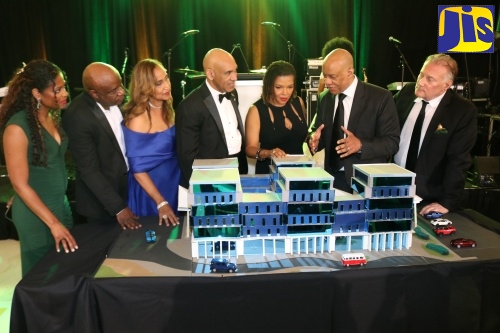 Minister without Portfolio in the Office of the Prime Minister with Responsibility for Efficiency, Innovation and Digital Transformation, Hon. Ambassador Audrey Marks (third right), and Jamaica’s Ambassador to the United States (U.S.), His Excellency Major General (Ret’d) Antony Anderson (centre), listen as architect, Christopher Carter (second right), outlines the prototype for a full replacement facility proposed to be built for Percy Junor Hospital in Manchester by the U.S.-based non-profit Diaspora organisation - Right Now For Jamaica (RNFJ). Looking on (from left) are RNFJ Director - Dr. Mikki Lake, Vice President - Dr. Maurice Miles, Director - Dr. Trudy Hall, and President - Ronald McKay. The prototype was unveiled during RNFJ’s inaugural fundraising gala, held March 28 at the Royal Ballroom in Bowie, Maryland.